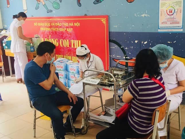 Các bác sĩ, điều dưỡng viên của Bệnh viện Hồng Sơn phục vụ việc tiêm chủng ở Trạm Y tế phường Giáp Bát